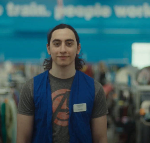A person at work, standing in front of donated goods for selling