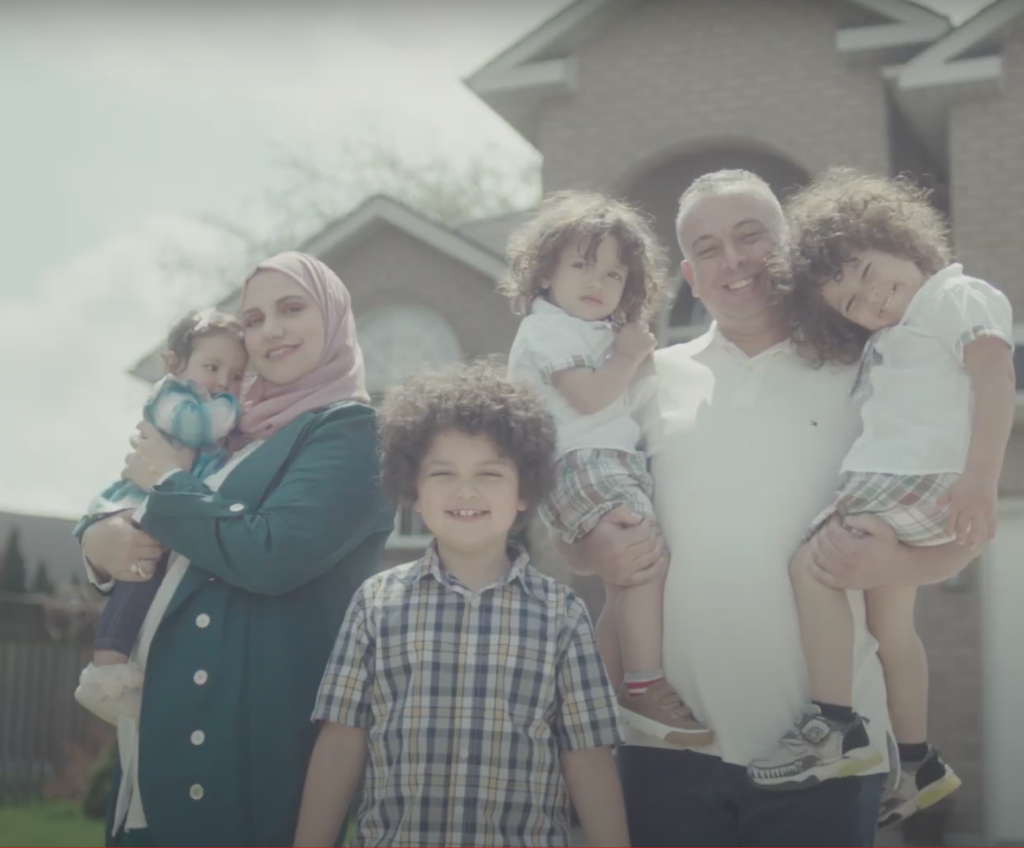 A family photo with kids, a mother carrying his youngest and a father carrying two toddlers on his arms