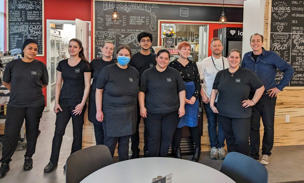 The Edgar and Joe's Café team stand together in front of the café counter.