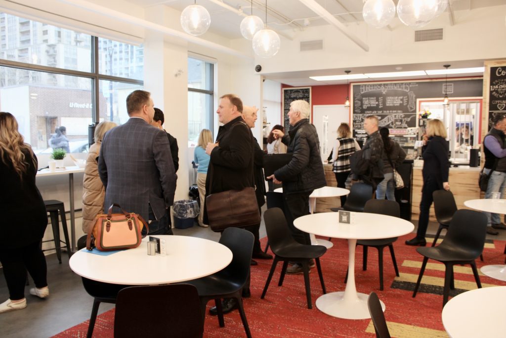 A large group chats and enjoys refreshments at the grand opening of Edgar and Joe's Café.