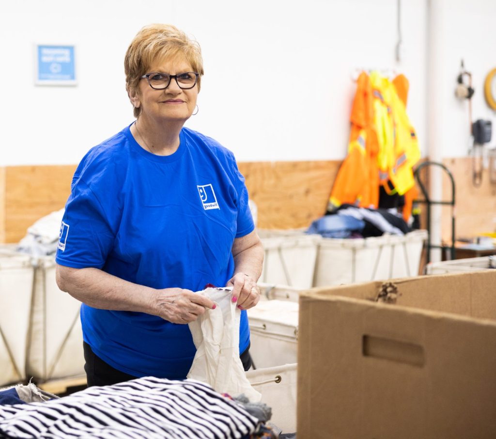 woman sorting through donations in the back room of a Goodwill